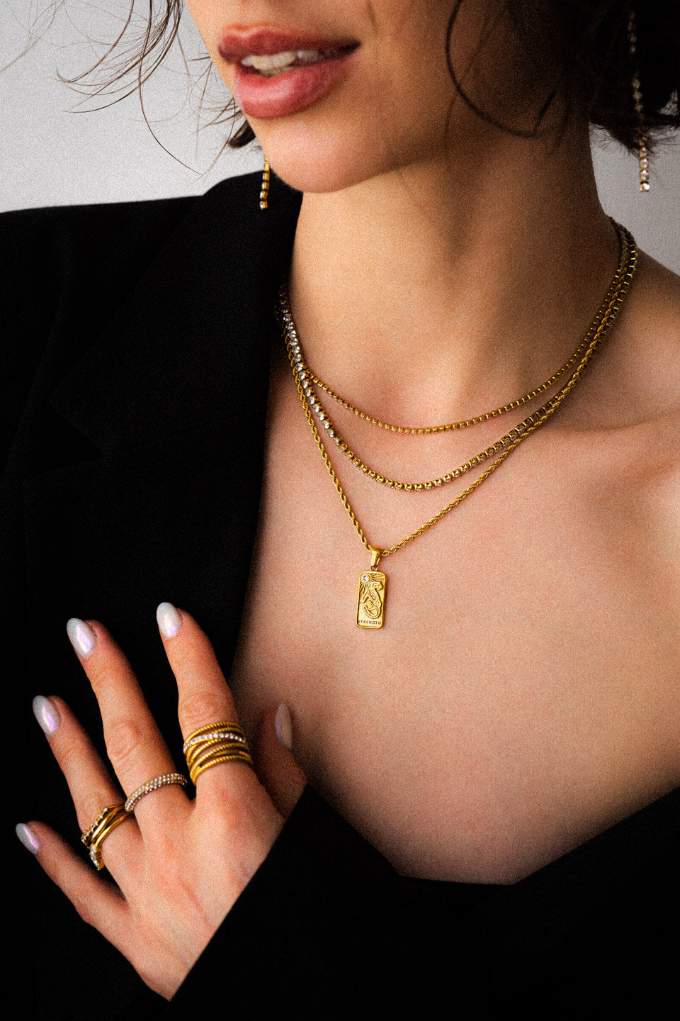 Model mit schwarzem Blazer und viel Goldschmuck