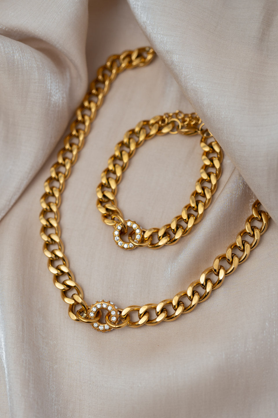 Chunky Schmuckset aus Halskette und Armband, beide haben einen auffälligen, runden Anhänger mit Zirkonia Steinen