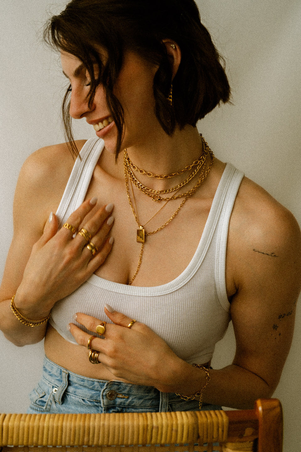 Frau mit weißem Top und vielen Ketten, Ringen und Armbändern