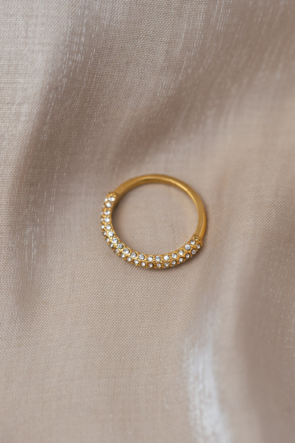 Goldener Ring, der zur Hälfte mit vielen kleinen Zirkonia Steinen besetzt ist